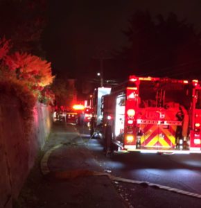 Hose line extends from a responding fire engine in response to apartment fire