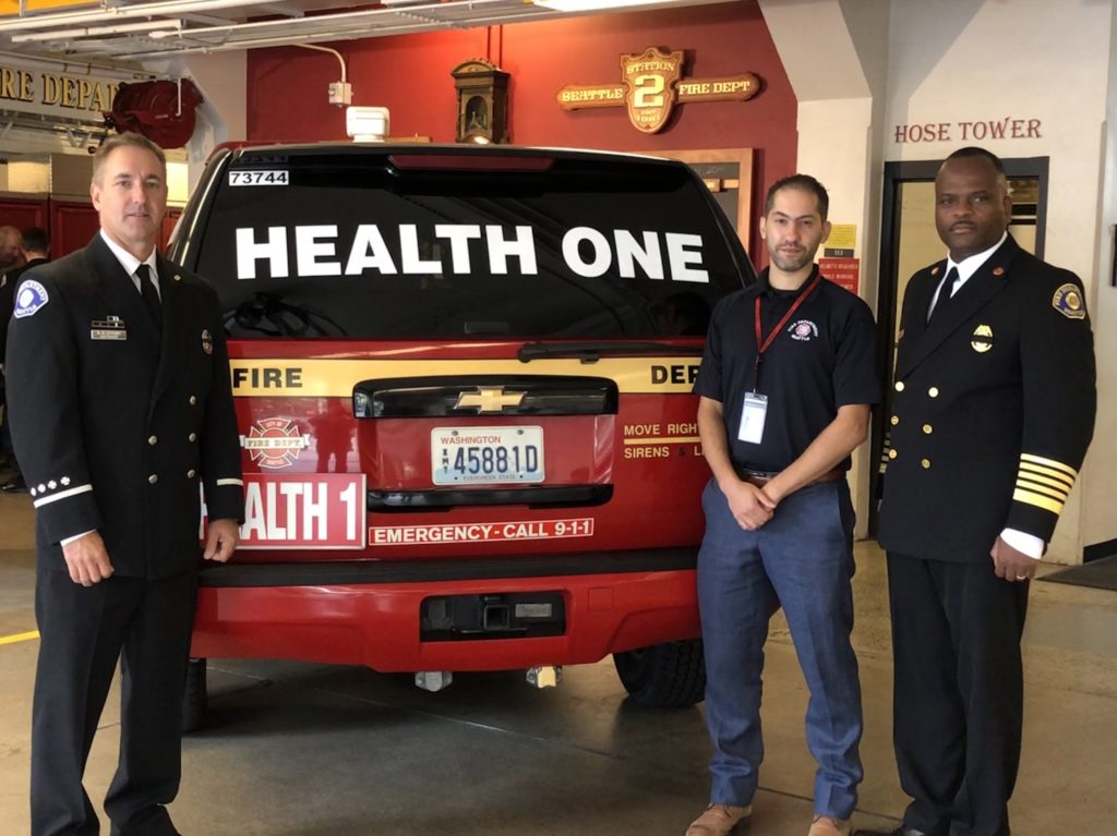 The Local 27 president, the Seattle Fire Low Acuity program manager and Seattle Fire Chief stand by the department's new Health One vehicle. 