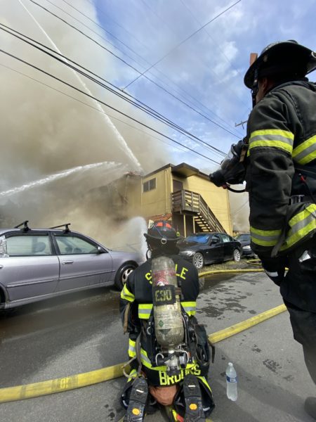 Firefighters pour water onto the building on fire.