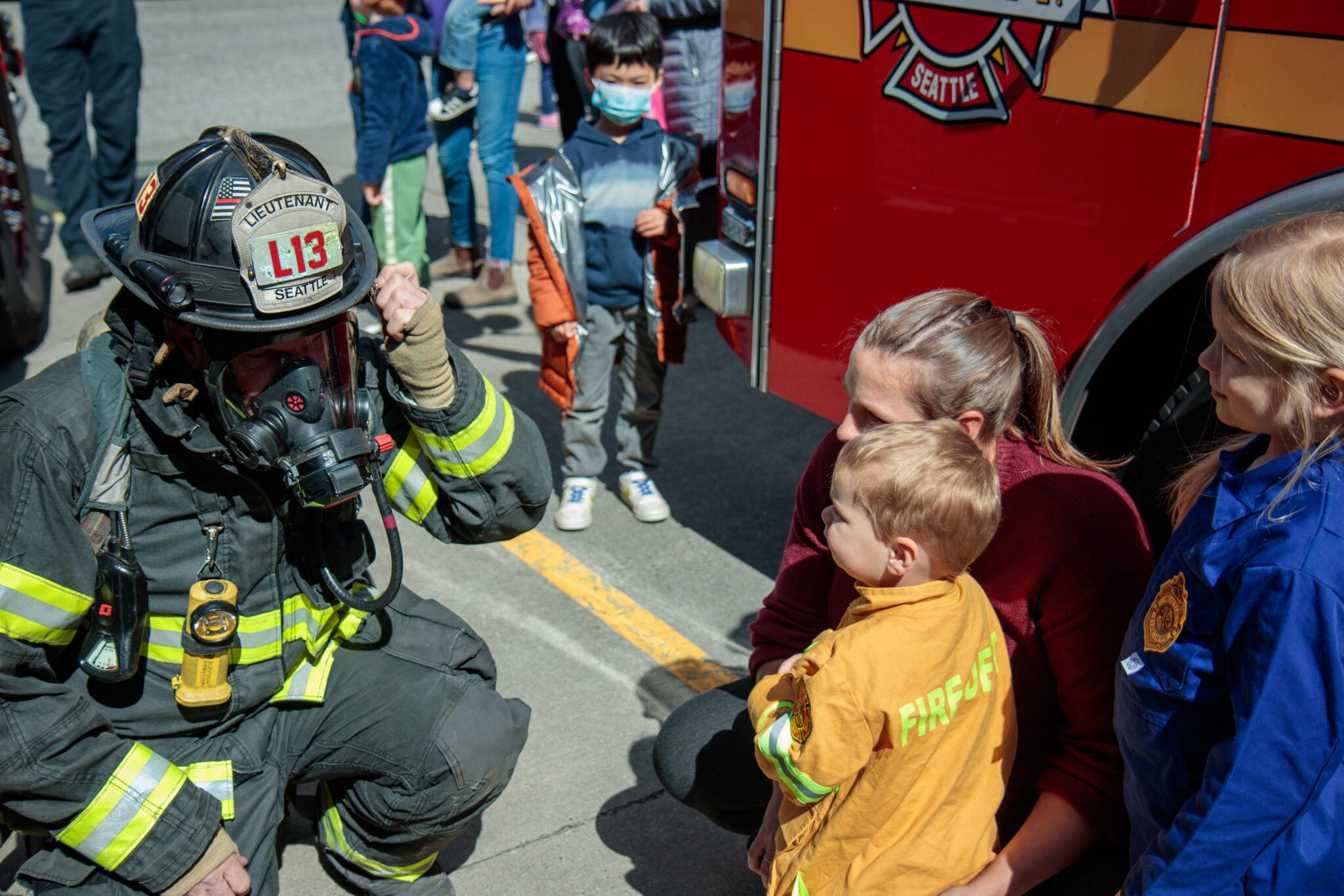 Firefighter greeting children.