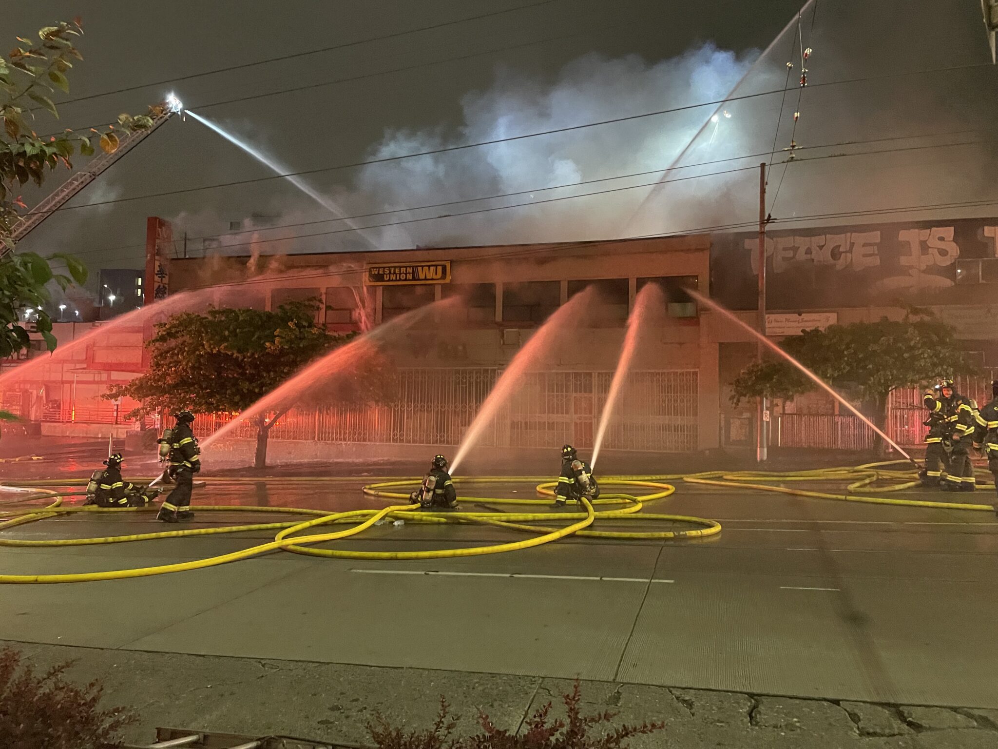 Firefighters use hoses to pour water in a building that is on fire