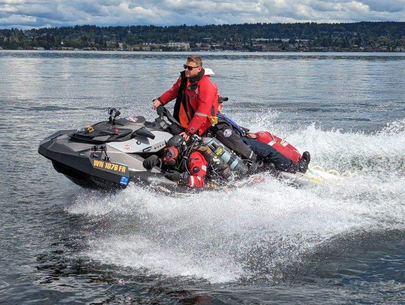 Seattle firefighter riding a SeaDoo rescue watercraft on a lake for training