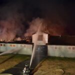 Firefighters put water on a building fire.
