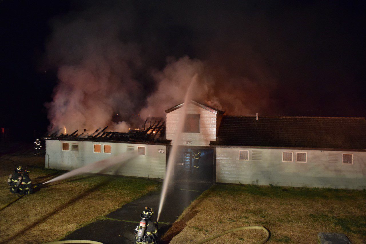 Firefighters put water on a building fire.