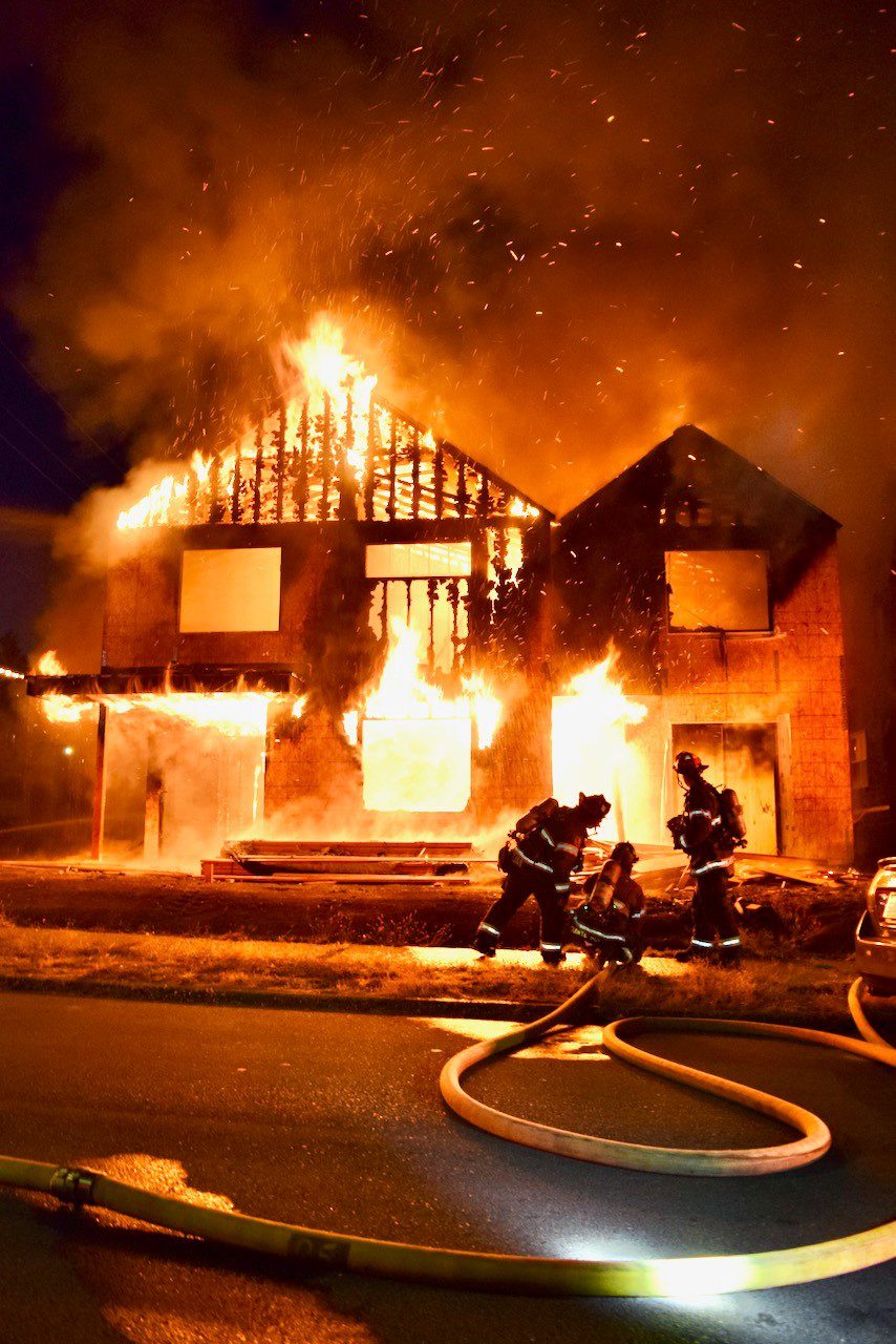 Firefighters put water on a fire involving a residence under construction.