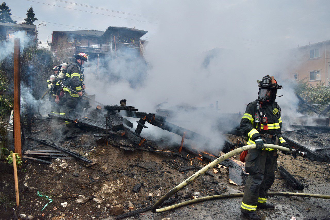 Firefighters extinguish a fire involving a detached garage.