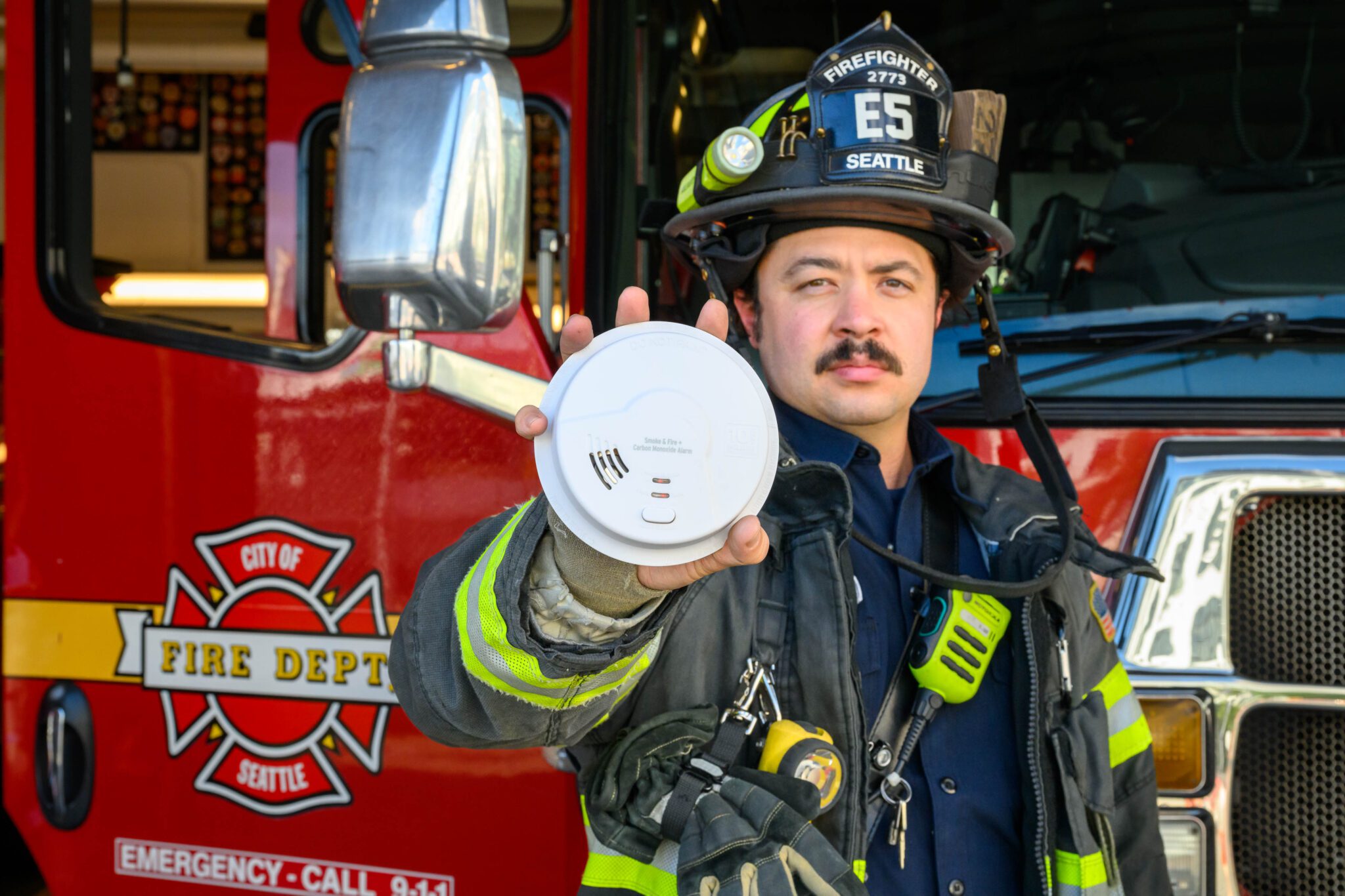 firefighter holding smoke alarm