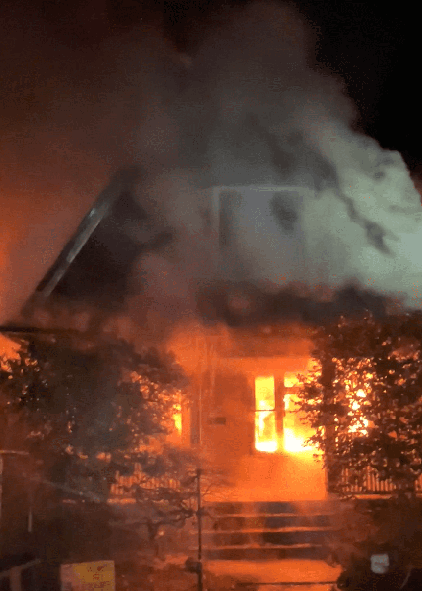 Flames showing from the first floor of a home.