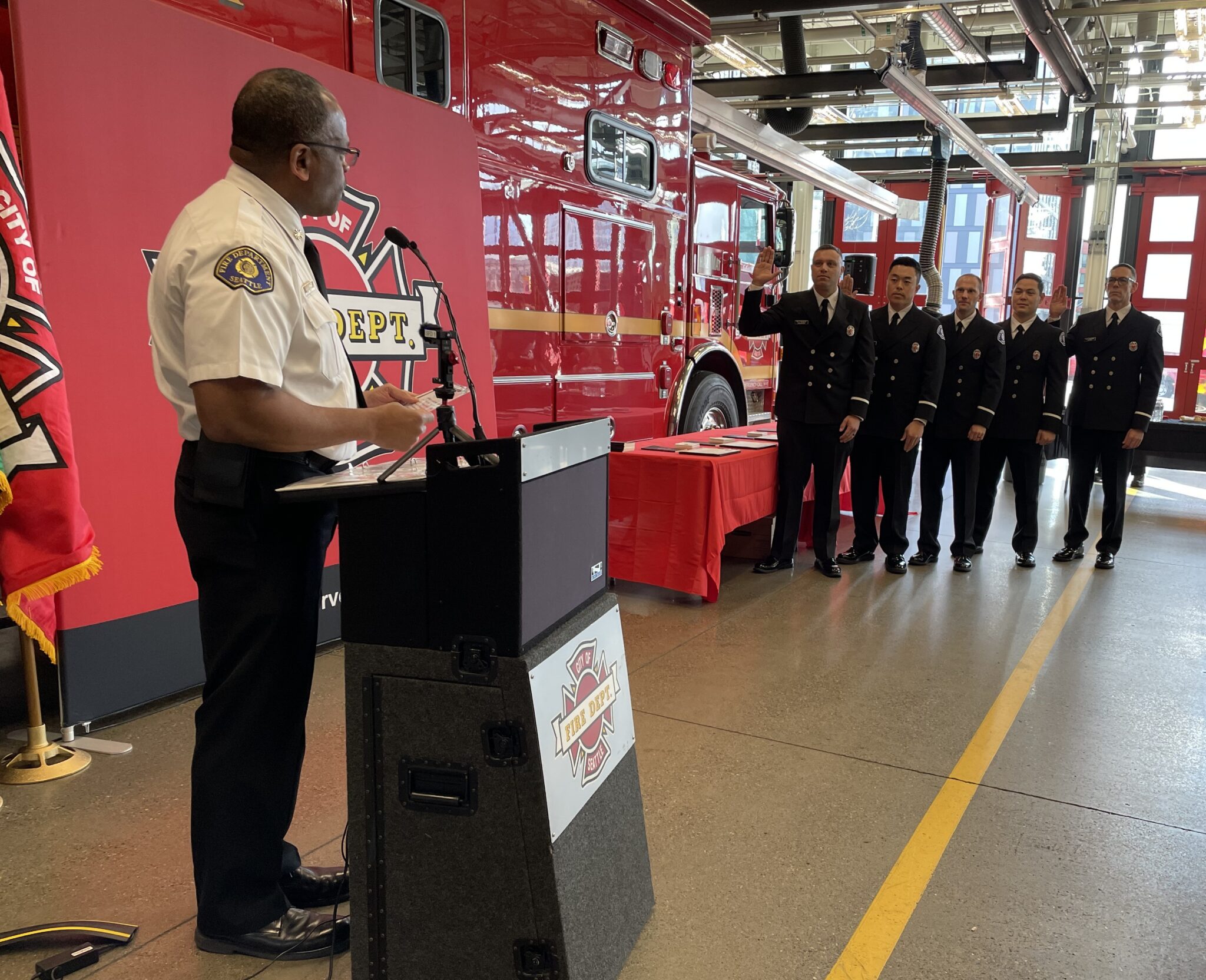 Fire Chief, Harold Scoggins reads the oath to promoting Lieutenants