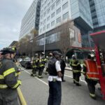 Firefighters stand in front of building