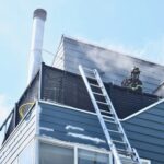 Firefighter working on the roof of a house on fire.