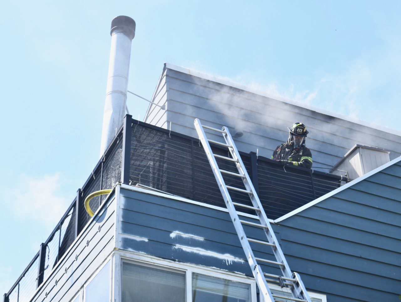 Firefighter working on the roof of a house on fire.