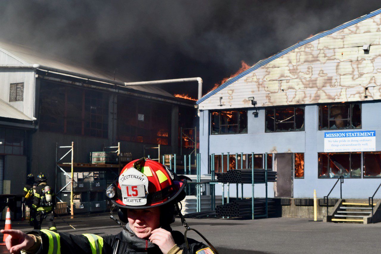 Lieutenant speak into radio at fire scene.