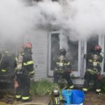 Firefighters working to extinguish a house fire