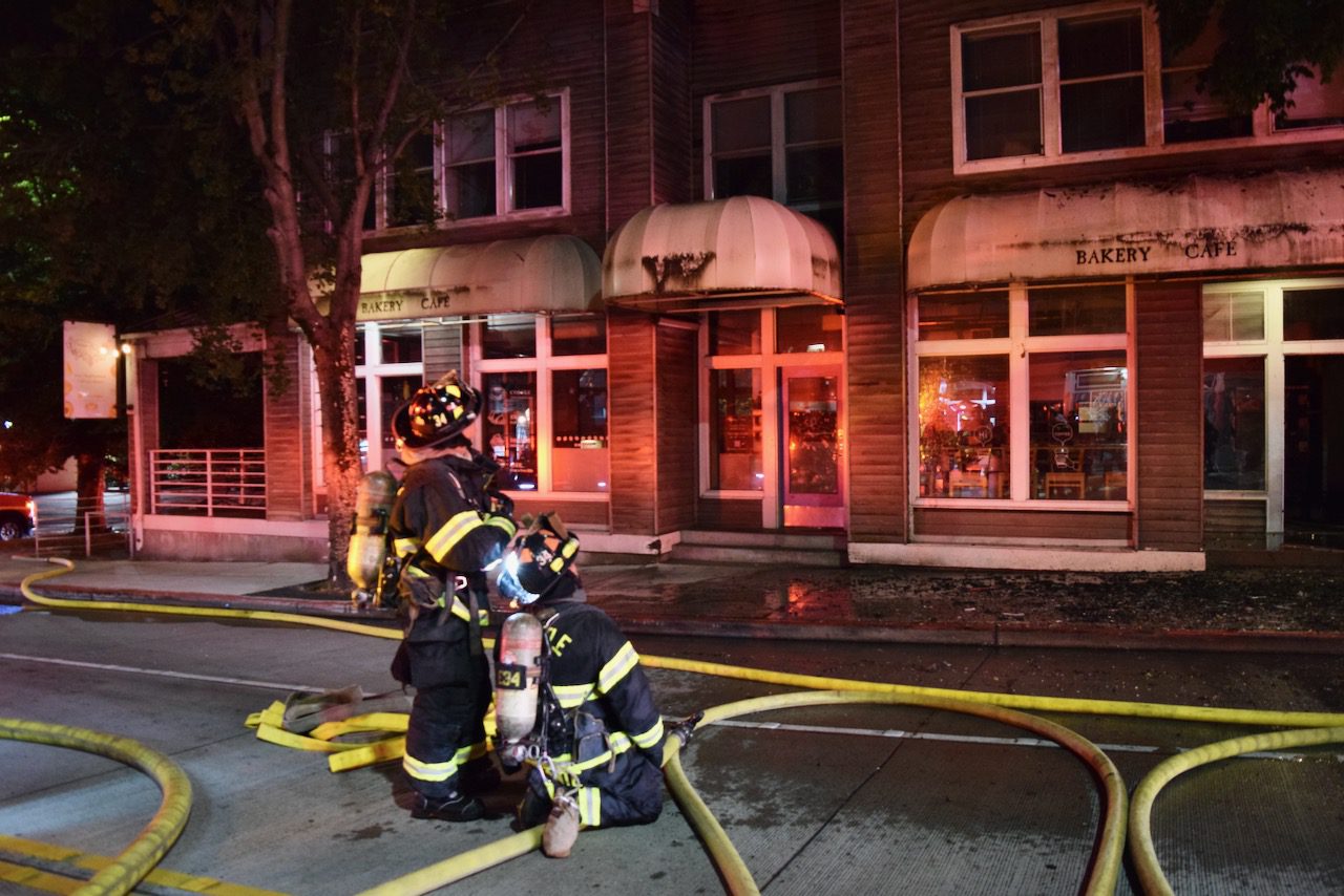Firefighters work to put water on a building on fire.