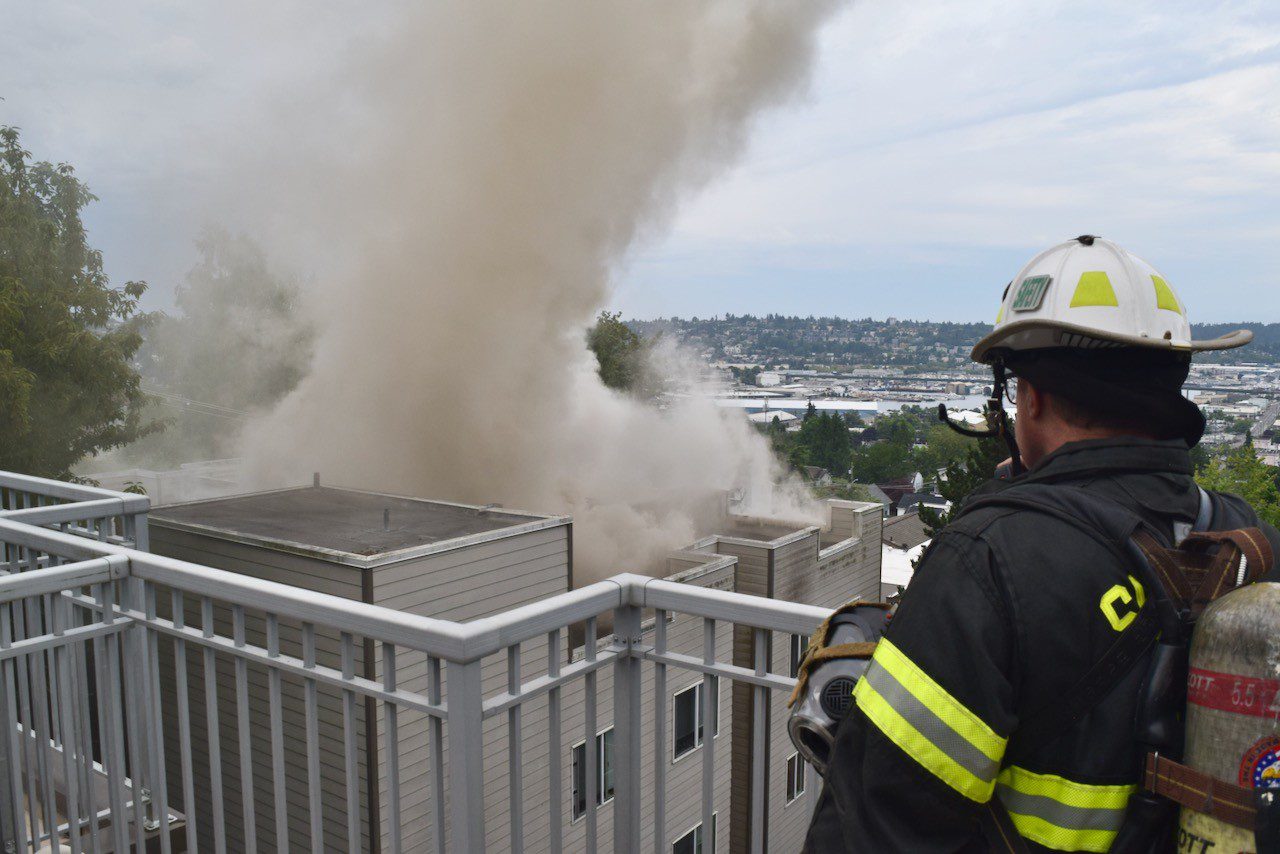 The safety Chief views rooftop fire from different building balcony.