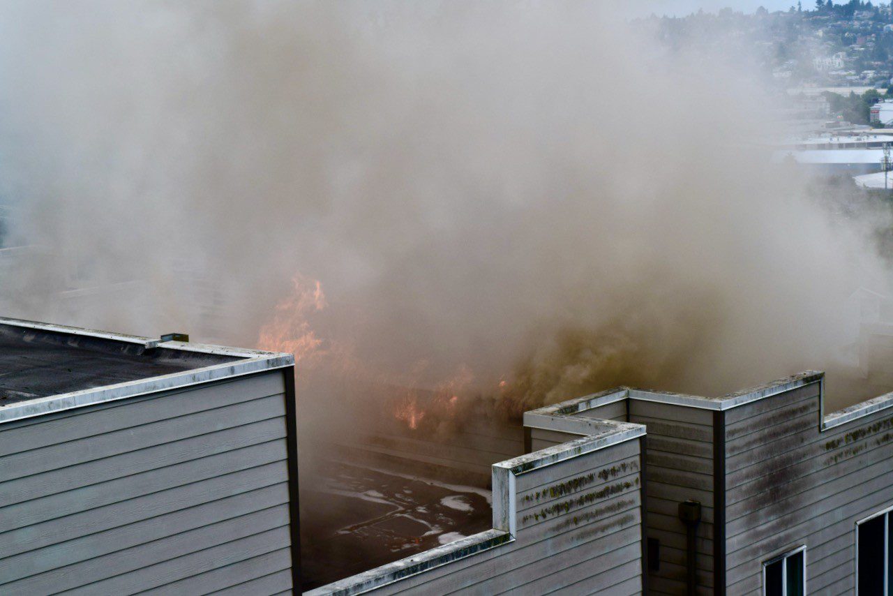 Flames visible on the roof of apartment building.