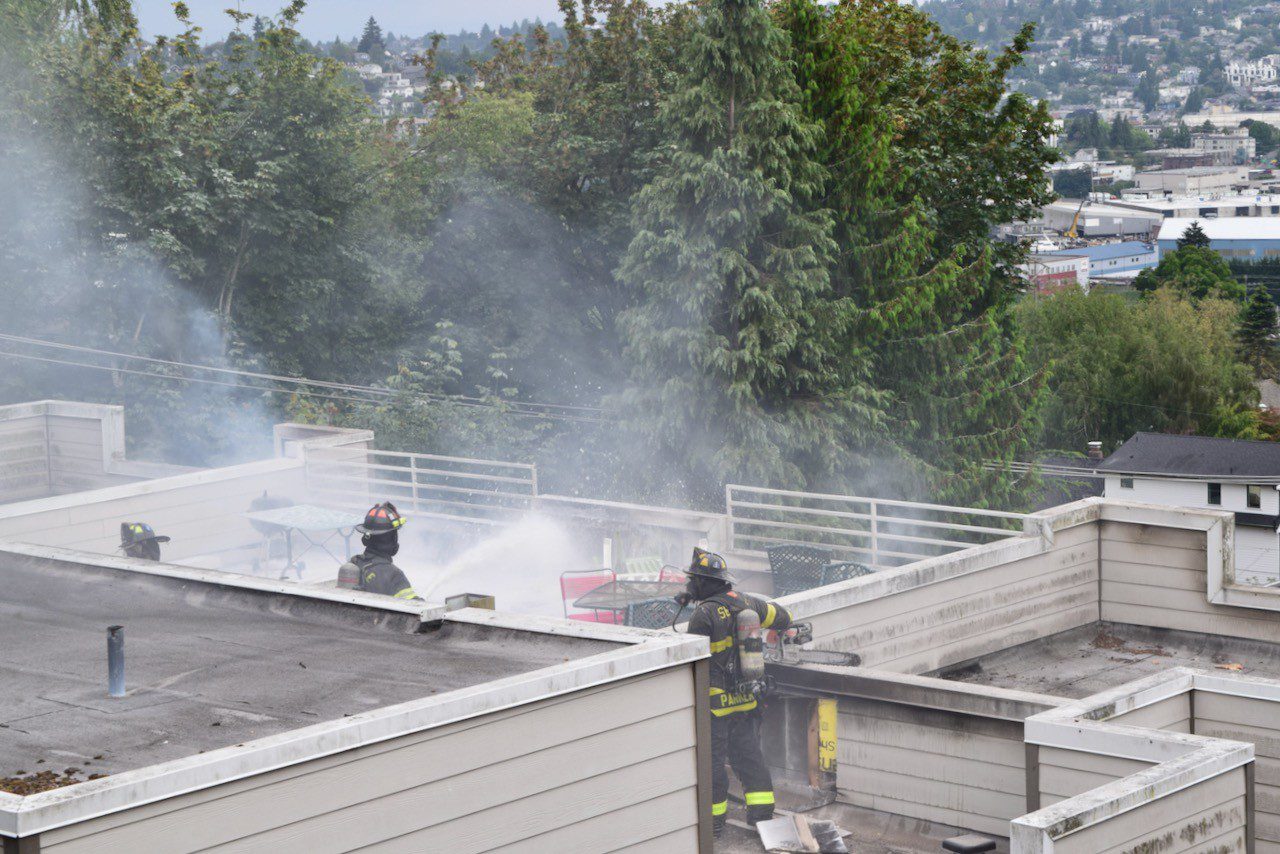 Firefighters put water on the rooftop fire